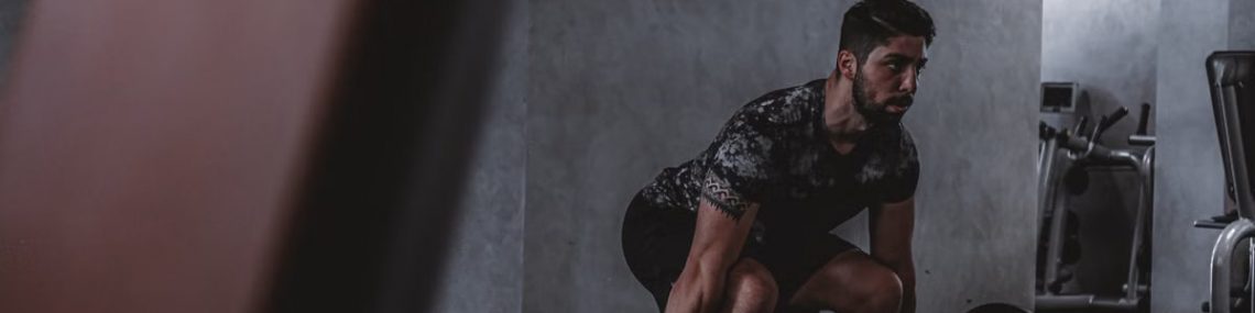 Man lifting weights in gym, displaying strength and focus. Ideal for fitness and training themes.